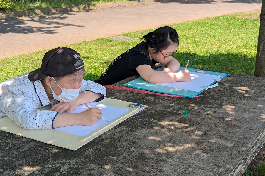 外で寝そべってスケッチを描く